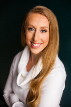 Headshot of Dr. Adrienne VanZomeren, a woman with long blonde hair wearing a white turtleneck sweater.